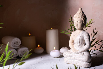 Beauty wellness concept with statue of Buddha with burning candles for spa time.  Religion concept.