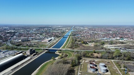 Aerial shot of a river with a bridge with a cityscape in the background