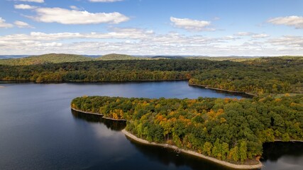 Fototapeta na wymiar Drone shot of the New Croton Reservoir on a sunny day in autumn with a blue cloudy sky