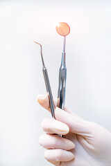 Sterile dental tools in hands. Orthodontic mirror accessory.