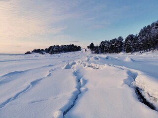 Winter landscape in Kandalaksha, Kola Peninsula, Murmansk region. Cracks in the ice of frozen White sea.