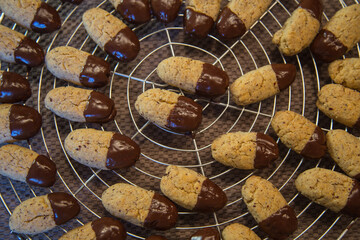 Christmas bakery: Fresh and delicious homemade hazelnut cookies for advent or christmas - currently  baked and garnished with chocolate, made with love, blurred background, close up