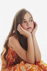 Pensive teen girl with long hair props chin with hands