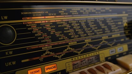 Front panel of vintage radio with radio wave frequency and buttons. Dashboard of an analog old radio close up. Antique radio speaker for listening to media and music. Retro background, nostalgia.