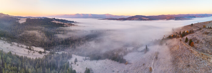 Mountain autumn misty Sunrise panorama. Majestic Morning fog, November Valley Aerial scene. Ice, frost on grass. Fall sunny Landscape, forest hills. Beautiful tonal perspective - 545258768