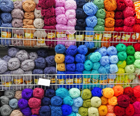 A lot of colorful yarn on the shelves in the store
