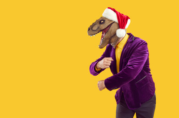 Excited man wearing red Christmas cap, purple velvet jacket and funny dinosaur reptile lizard face...