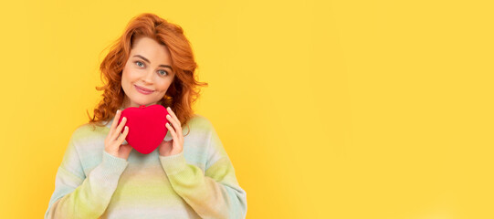 Woman isolated face portrait, banner with copy space. smiling redhead woman with red heart on yellow background.