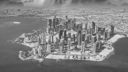 Aerial view of Doha skyline from airplane during a storm. Corniche and modern buildings, Qatar