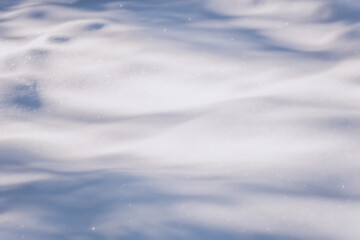 White snow in sunlight on a clear frosty day. Shadows on the snow. Bright snowy background with empty field for montage. Christmas background with snow. Natural wallpape
