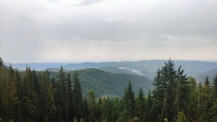 Summer and autumn hiking in the Carpathian mountains, stunning views from the tops, blue cloudy sky, fog