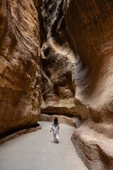 Petra, Jordan - October 27 2022: The Siq Gorge Entrance to the Nabatean City Petra with a Young Girl wearing a Keffiyeh Scarf.