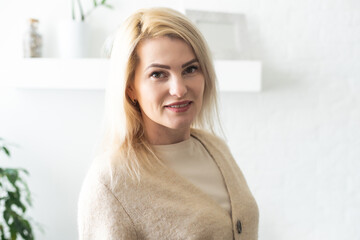 Naklejka premium Portrait of young smiling woman looking at camera with crossed arms. Happy girl standing in creative office. Successful businesswoman standing in office with copy space