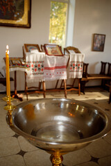 The sacrament of baptism in an Orthodox church in Ukraine. Candles and a bath for the baby. In the...