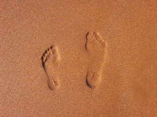 Fototapeta na wymiar Footprints in cinamon sand on XI beach,greece, love vacation memory, text space, background, couple goals, travelling together, 