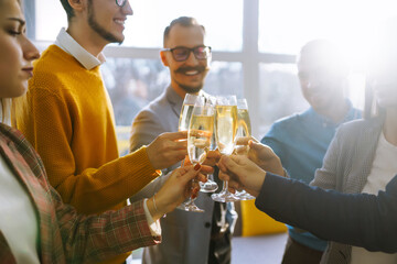 Toasting to success concept.Group of young business people toasting each other and smiling while standing in the office. Celebration and festive concept.