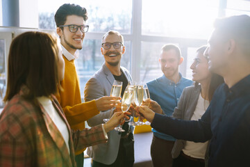 Toasting to success concept.Group of young business people toasting each other and smiling while...