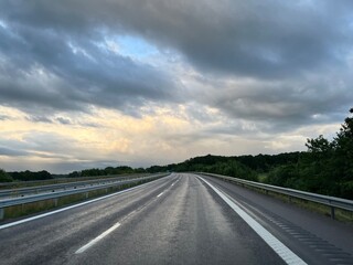 Empty highway in the fields, stormy sky