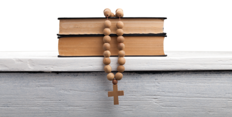The book of Catholic and rosary beads on the wooden table