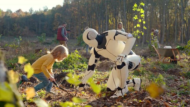 Happy child working together with robot and planting seedling of tree in garden or forest on sunny autumn day. Outdoor. Caucasian kid girl cooperating with humanoid for anti deforestation.