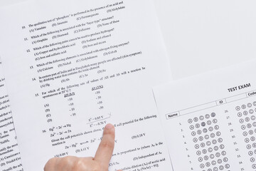 a person's hand pointing at the numbers on a piece of paper that has been printed out for use