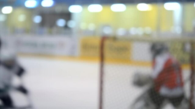 Blurred background. Teams of hockey players playing hockey. Teenage boys play hockey on ice rink at indoor ice stadium. Ice Hockey match championship Sports skating competitions Real professional game