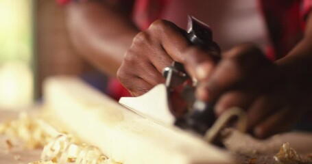 Profession, people, carpentry, woodwork - Female carpenter working with plane and wood plank at workshop