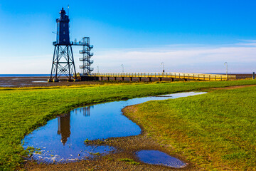 Black lighthouse tower Obererversand Wadden Sea landscape in Dorum Germany.