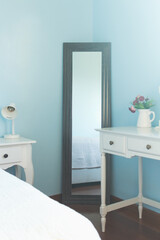 Bed reflection in the mirror. Modern feminine classic design. Comfortable home interior