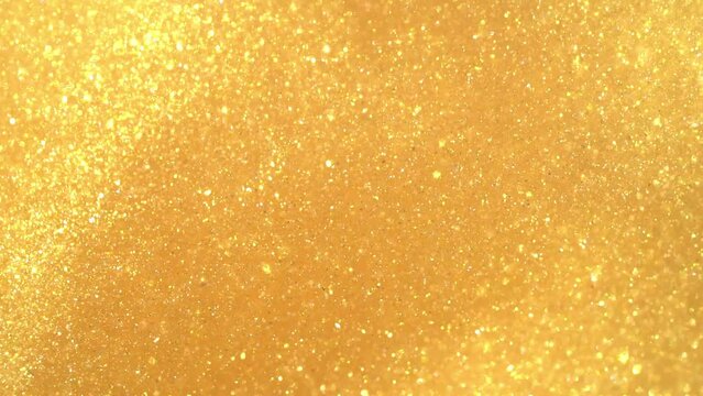 A movement of gold dust particles. A moving, flowing, stream of Golden particles in sinuous, wavy lines. Chaotic movement of moving shiny glitters . Gold flying particles abstract background. 