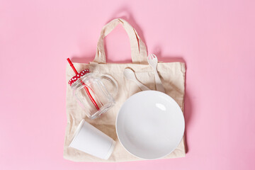 a cup and plate on a pink background with a tote bag next to it, the bowl is empty
