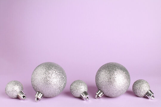 Wallpaper greeting card Merry Christmas holiday composition with silver toy ball decoration on lilac violet purple background. Xmas New Year winter design idea concept. Copy space. Space for text