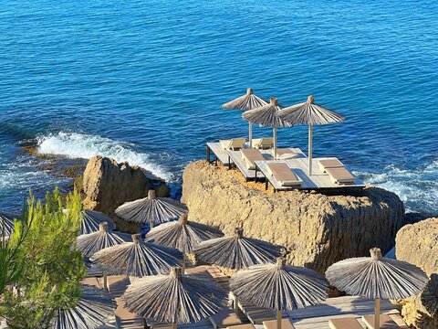 Beach umbrellas on the rocky sea shore at summer.