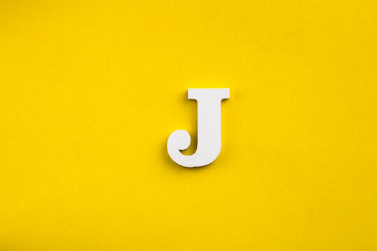 letter J uppercase - white wood letter on yellow color background