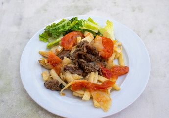 Vietnamese stir fried macaroni with beef. Beef is fermented with salt, black pepper and stir fried seperately. Onions and tomatoes are then stirred fried and added with the beef. Macoroni is cooked.