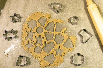 Christmas baking.Ginger dough for gingerbread,gingerbread men,stars,Christmas trees,rolling pin,spices (cinnamon and anise),flour,cane sugar,eggs.On the home kitchen wooden table.Copy space top view