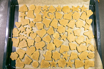 Christmas baking.Ginger dough for gingerbread,gingerbread men,stars,Christmas trees,rolling pin,spices (cinnamon and anise),flour,cane sugar,eggs.On the home kitchen wooden table.Copy space top view