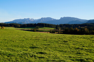 Obraz premium hiking trail overlooking scenic alpine lake Attlesee and the vast, lush, green meadows in the Bavarian Alps, Nesselwang, Allgaeu or Allgau, Germany 