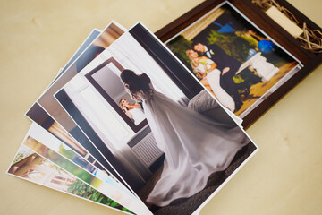 printed wedding photos and a wooden box with a flash drive. 