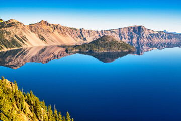 View of Crater Lake with perfect reflections on a calm summer morning.