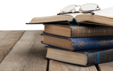 Stack old books with reading glasses on desk