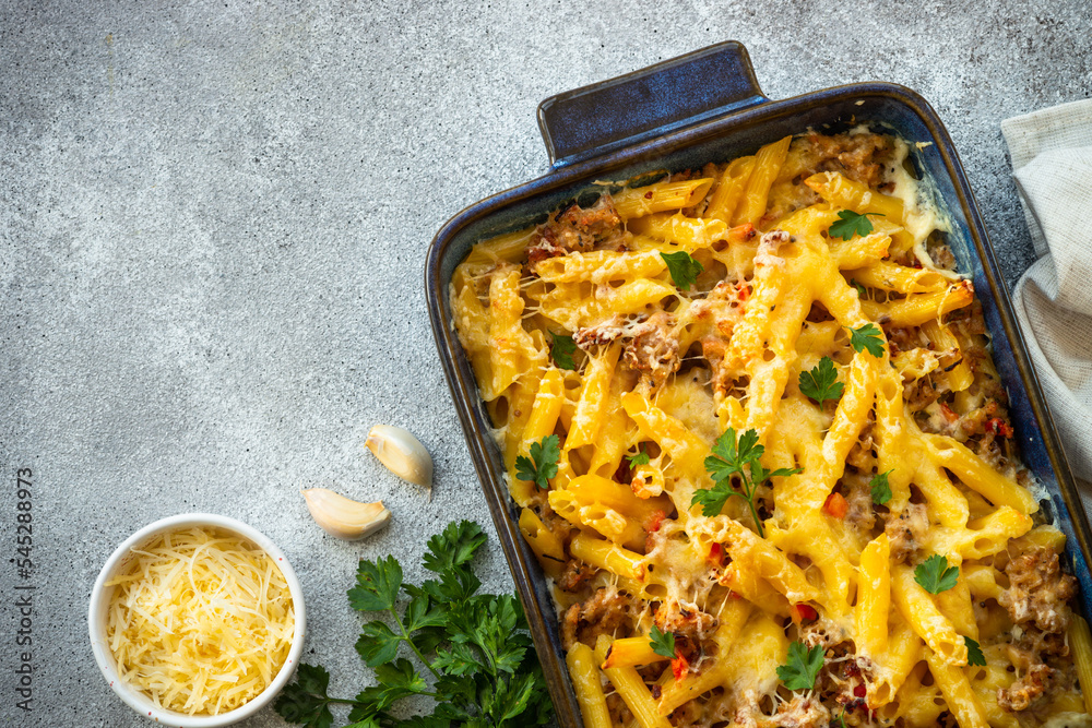 Sticker pasta penne with minced meat, cheese and creamy sauce. mac and cheese. top view on stone table.