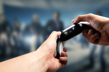 Fototapeta premium Entertaining video games. A gamer holds a GAM22ICB joystick in his hands. The background is a video game on the big screen of a personal computer, TV. Virtual reality, cyberspace.