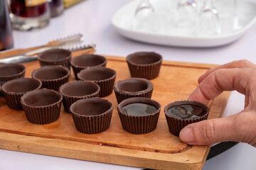 Men hand picking the traditional Ginja de Obidos, traditional sour cherry liqueur, served in small cups made of chocolate. Obidos, Portugal