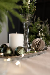 Festive New Year's table with candles and handmade Christmas decorations and live floristry