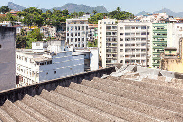 Corrugated asbestos cement roofing and cityscape, demolition site with an asbestos issue, Rio de...