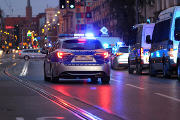 Akcja nocna alarmowa policji w mieście - Sygnalizator błyskowy niebieski na dachu radiowozu policji polskiej w nocy. Światła policyjne.