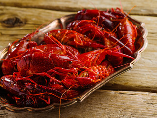 Appetizing boiled crayfish in a bowl on a wooden background. Close-up. Cooking seafood dishes. Recipes for home and restaurant cuisine. There are no people in the photo.