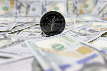 Classic navigational compass on the background of one hundred dollar bills