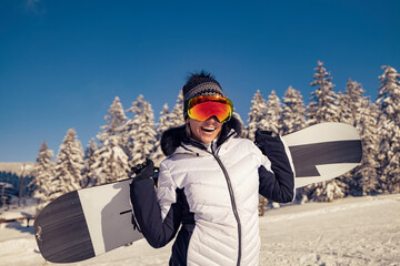 Fototapeta na wymiar Portrait of snowboarder at top of ski slope